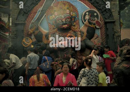 Persone che si rivolgono a pregare all'immagine di Kala Bhairava, celebrando Bishak 1 °--il nuovo anno ufficiale nepalese--a Piazza Durbar, Kathmandu, Nepal. Foto Stock