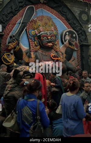 Persone che si rivolgono a pregare all'immagine di Kala Bhairava, celebrando Bishak 1 °--il nuovo anno ufficiale nepalese--a Piazza Durbar, Kathmandu, Nepal. Foto Stock