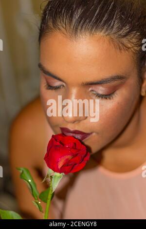 Una ragazza che annodava una rosa rossa Foto Stock