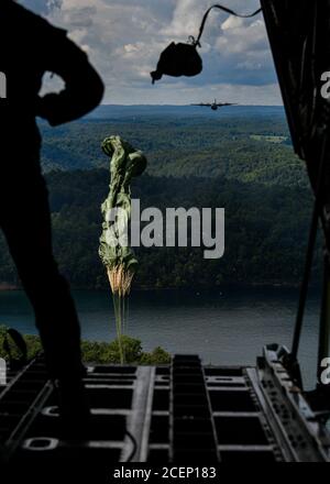 Un paracadute attaccato al carico si apre dopo essere stato spinto fuori dalla parte posteriore di un aereo C-130H Hercules da un maestro di carico il 23 agosto 2020, sopra il lago di Summerville, West Virginia. Cinque unità di riserva dell'aeronautica della ventiduesima unità dell'aeronautica e di una Guardia nazionale dell'aria della Virginia occidentale hanno partecipato al Rally nella valle, un'esercitazione di addestramento del C-130 multi-giorno sotto un concetto distribuito di operazioni, 22-25 agosto 2020. L'esercizio includeva gocce di carico, gocce di paracadutisti ad alta quota, rifornimento della task force ed estrazione del personale. (STATI UNITI Air Force photo/Senior Airman Christina Russo) Foto Stock