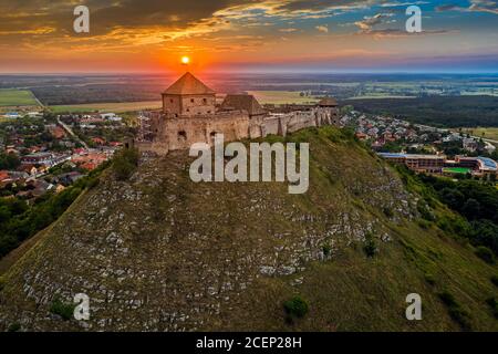 Sumeg, Ungheria - Vista aerea del famoso Castello di Sumeg nella contea di Veszrem al tramonto con nuvole colorate e colori drammatici del tramonto a bac Foto Stock