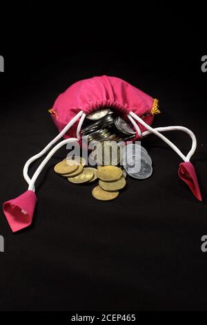 Sacco rosa con monete in valuta indiana. Moneta in sacco di cotone con soldi. Impilando moneta in sacco su sfondo nero, Money stack per la pianificazione aziendale Foto Stock