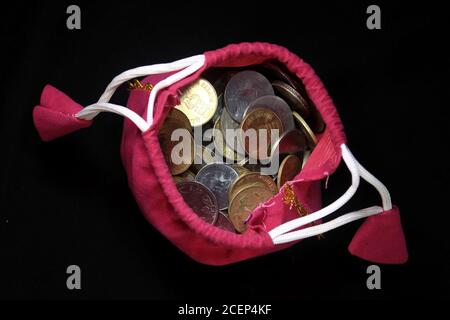 Sacco rosa con monete in valuta indiana. Moneta in sacco di cotone con soldi. Impilando moneta in sacco su sfondo nero, Money stack per la pianificazione aziendale Foto Stock