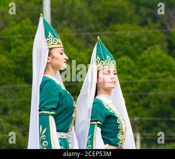 Adygea, RUSSIA - LUGLIO 25 2015: Giovani ragazze ballerine in abiti tradizionali Adyghe, danza in un festival etnico nelle colline del Caucaso ad Adygea Foto Stock