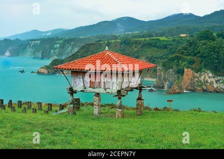 Vecchio granaio rialzato alto sopra le scogliere verdi e rocciose con vista se Foto Stock