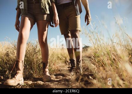 Primo piano di gambe di due persone che camminano su un sentiero escursionistico. Coppia a piedi su un percorso accidentato con scarpe da trekking. Foto Stock