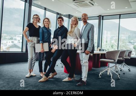 Un team di colleghi che si riuniscono nella sala riunioni. Gruppo di uomini d'affari dopo una riunione. Foto Stock