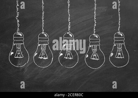 Fila di lampadine gesso disegno su lavagna. Concetto di idea. Foto Stock