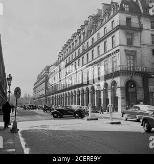 Anni '50, vista storica da questa epoca di Rue Saint-Honore e gli edifici circostanti, tra cui il famoso Hotel lotti a Parigi, Francia. L'hotel è stato fondato nel 1910 dal Duca di Westminster ed è stato situato in un vecchio convento giacobino, diventando popolare tra gli aristocratici e i borghesi, che lo hanno battezzato "il più piccolo dei grandi hotel". Foto Stock