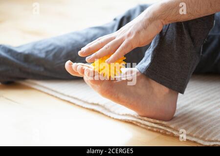 uomo che fa la correzione del piede piatto auto massaggio a casa Foto Stock
