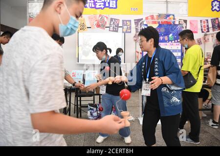 (200902) -- CHANGSHA, 2 settembre 2020 (Xinhua) -- Noriko Nakamura (R, front) suona Kendama, un giocattolo tradizionale giapponese, con partecipanti a un evento culturale offline tenutosi presso la Sala espositiva della Provincia di Hunan a Changsha, Provincia di Hunan della Cina centrale, 21 agosto 2020. Sono passati 18 anni da quando Noriko Nakamura ha iniziato la sua carriera come insegnante di lingua giapponese in Cina. Originario della Prefettura di Chiba, Nakamura aveva sempre aspirato ad essere un insegnante. Nel 2003, ha imparato da un documentario che molti studenti cinesi mostravano passione per la lingua giapponese, ma pochi insegnanti erano nati Foto Stock