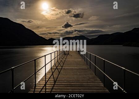 Guardando giù il molo del piroscafo Aira Force su Ullswater una notte illuminata dalla luna Foto Stock