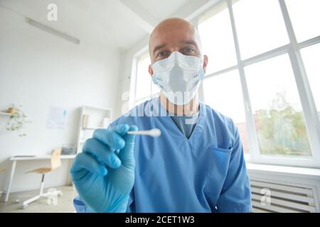 Orizzontale medio ritratto di medico generico indossando maschera protettiva e. guanti che devono sostenere il test con tampone Foto Stock