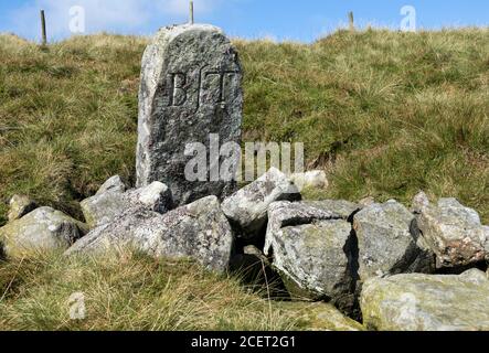 Pietra marcature scolpita che segna la sorgente delle T del fiume a Tees Head on Cross Fell, Cumbria, Inghilterra, Regno Unito, Foto Stock