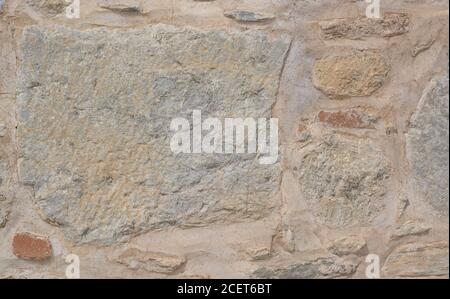 Grande pietra irregolare in un'antica posa di un muro Foto Stock