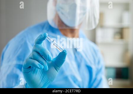 Testa tagliata primo piano di un lavoratore medico irriconoscibile che indossa personale ampolla protettiva uniforme con vaccino Foto Stock
