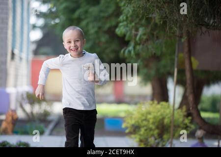 Bielorussia, la città di Gomel, 25 aprile 2019. Asilo aperto giorno. Felice ragazzo di sette anni che gioca su una strada estiva. Foto Stock