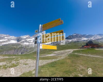 Cervinia, Italia - 12 luglio 2020: Cartello giallo con guida di escursionisti su diversi percorsi di montagna sopra Cervinia Foto Stock