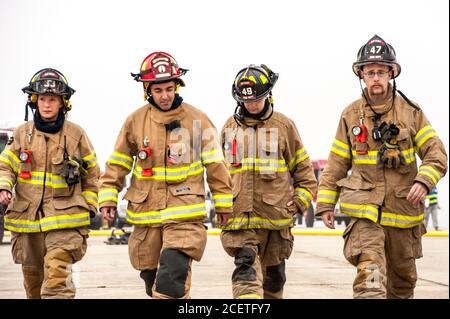 Quattro vigili del fuoco in uniforme che camminano verso la macchina fotografica durante un esercizio di emergenza a scala completa presso l'aeroporto internazionale di Pease a Portsmouth, New Hampshire. Foto Stock