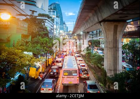 Guardando giù sulla congestionata Sukhumvit Rd vicino al raccordo di Asoke al crepuscolo. Ripresa da un percorso sopraelevato che attraversa la strada. Bangkok Thailandia. Foto Stock