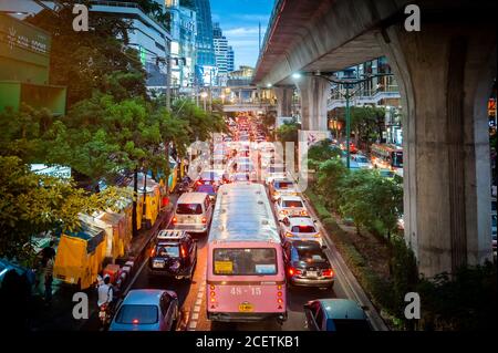 Guardando giù sulla congestionata Sukhumvit Rd vicino al raccordo di Asoke al crepuscolo. Ripresa da un percorso sopraelevato che attraversa la strada. Bangkok Thailandia. Foto Stock