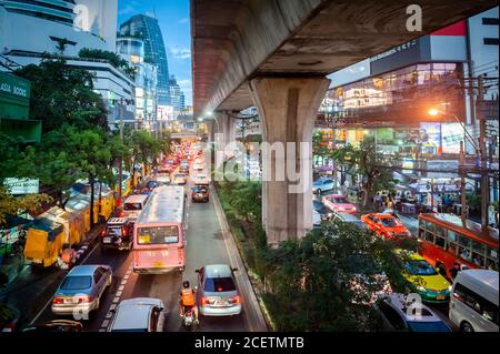 Guardando giù sulla congestionata Sukhumvit Rd vicino al raccordo di Asoke al crepuscolo. Ripresa da un percorso sopraelevato che attraversa la strada. Bangkok Thailandia. Foto Stock