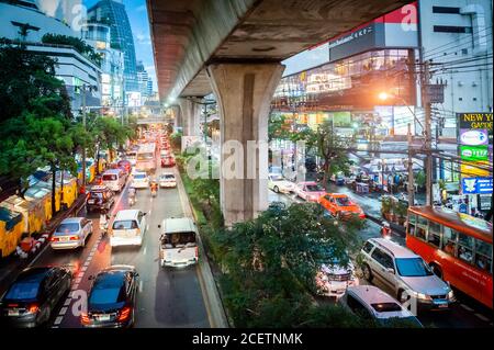 Guardando giù sulla congestionata Sukhumvit Rd vicino al raccordo di Asoke al crepuscolo. Ripresa da un percorso sopraelevato che attraversa la strada. Bangkok Thailandia. Foto Stock