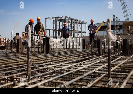 Vecchio impianto di fertilizzante fosfato in modernizzazione. Lavoratori che assemblano il rinforzo del nuovo seminterrato dell'edificio. Su edificio industriale, costruzione struttura Foto Stock