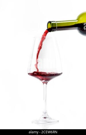 Bottiglia di vino rosso e vino isolato su sfondo bianco. Vino francese di lusso in bicchiere. Concetto di schizzi di vino. Degustazione di vini e restauri Foto Stock