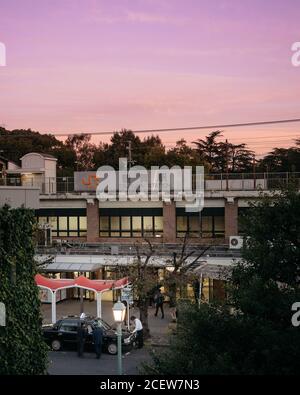 Nagoya, Aichi, Giappone - i tassisti si riposano di fronte all'ingresso della stazione ferroviaria di Tsurumai. Cielo bello e colorato al tramonto sera. Foto Stock