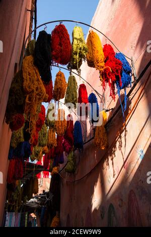 Matite di lana colorata drappeggiato da frangifferi nel Souk des Teinturiers, il souk del dyer all'interno della Medina, Marrakech Foto Stock