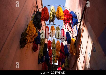 Matite di lana colorata drappeggiato da frangifferi nel Souk des Teinturiers, il souk del dyer all'interno della Medina, Marrakech Foto Stock