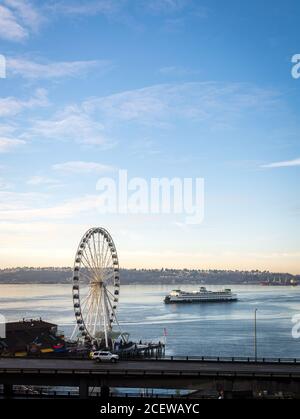 Seattle, Washington, Stati Uniti - Waterfront Park e la Seattle Great Wheel al mattino. Un traghetto che parte dal Molo di Seattle 55. Vista sulla città e sul porto. Foto Stock