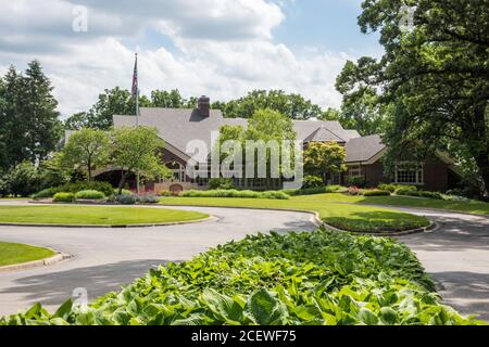 Aurora, Illinois, Stati Uniti-Aprile 19,2014: Stonebridge Country Club edificio con giardini coltivati e bandiera ad Aurora, Illinois Foto Stock