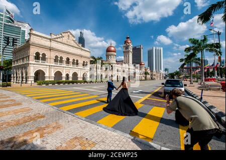 Kuala Lumpur, Malesia. 8 agosto 2020. La gente scatta foto di fronte alla piazza Merdeka a Kuala Lumpur, Malesia, 8 agosto 2020. Kuala Lumpur è la capitale e la più grande città della Malesia. Sviluppata da una città mineraria di stagno, la città è oggi ampiamente riconosciuta per numerosi punti di riferimento, tra cui le Torri Gemelle Petronas. La combinazione di grattacieli e siti storici e la coesistenza armoniosa di culture diversificate aggiungono alla città un fascino particolare. Credit: Zhu Wei/Xinhua/Alamy Live News Foto Stock