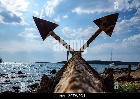 Vecchia ancora arrugginita inutilizzata sulla riva del mare Foto Stock