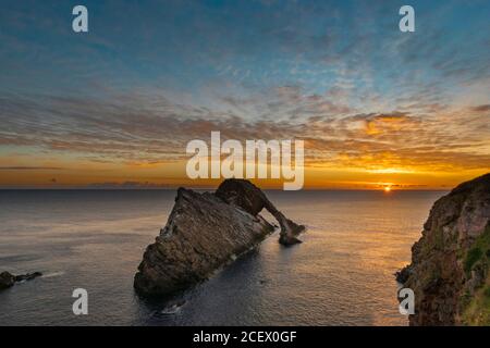 BOW FIDDLE ROCK PORTKNOCKIE MORAY COSTA SCOZIA PRIMO MATTINO GOLDEN ALBA SOLE ALL'ORIZZONTE E UN MARE AZZURRO CALMO Foto Stock