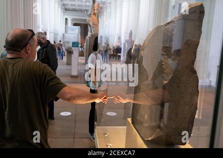 Riaperto dopo mesi di chiusura durante la pandemia di Coronavirus, alcuni dei primi visitatori che hanno prenotato biglietti gratuiti, possono ancora una volta ammirare i manufatti storici, tra cui la Rosetta Stone, al British Museum, il 2 settembre 2020, a Londra, Inghilterra. Foto Stock