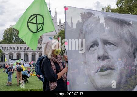 Dopo una pausa rinviata a causa della pandemia di Coronavirus, gli attivisti del cambiamento climatico protestano con un banner che presenta l'immagine del primo ministro Boris Johnson in Piazza del Parlamento, il 2 settembre 2020, a Londra, Inghilterra. Foto Stock