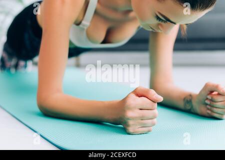 Fuoco selettivo di sportswoman che fa la pancia sul tappeto di idoneità a. casa Foto Stock