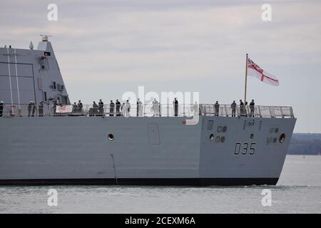 Equipaggio sul ponte di volo della Royal Navy Type 45 cacciatorpediniere HMS DRAGON mentre naviga dal Naval Base Foto Stock