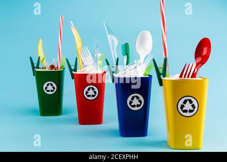 contenitori di riciclaggio multicolore con plastica su sfondo blu Foto Stock