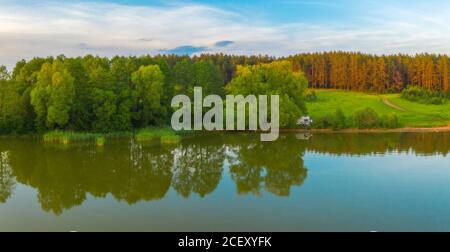 il camper si trova vicino alla foresta e al lago in autunno. Filmato con un drone Foto Stock