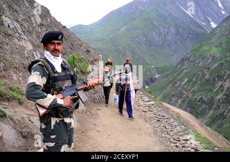 I devoti indù visitano durante il loro pellegrinaggio dal campo base di Baltal al luogo santo Amarnath Cave Shine situato ad un'altitudine di 12,729 piedi. Foto Stock