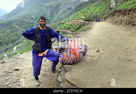 I devoti indù visitano durante il loro pellegrinaggio dal campo base di Baltal al luogo santo Amarnath Cave Shine situato ad un'altitudine di 12,729 piedi. Foto Stock