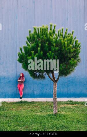 Atleta araba in hijab e abbigliamento attivo che pende sopra edificio moderno con vista Foto Stock