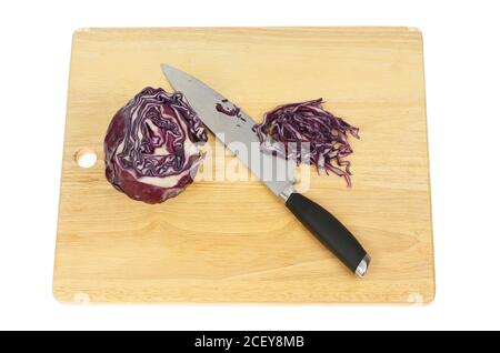 Cavolo rosso con un coltello su un tagliere di legno isolato contro il bianco Foto Stock