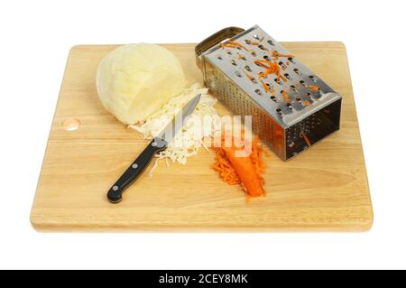 Ingredienti di coleslaw su un tagliere di legno isolato contro il bianco Foto Stock