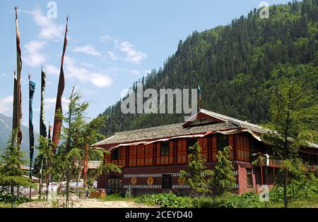 Juizhaigou (Valle dei nove villaggi) a Sichuan, Cina. Edifici in stile tibetano e bandiere di preghiera. Foto Stock