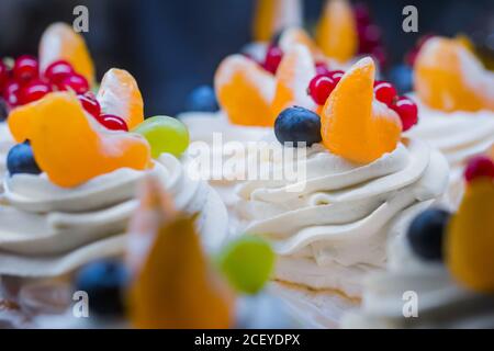 Assortimento di deliziose torte di crostata fresche con panna, frutta e bacche in vendita al banco del negozio, alimentari, mercato, caffè o panetteria Foto Stock